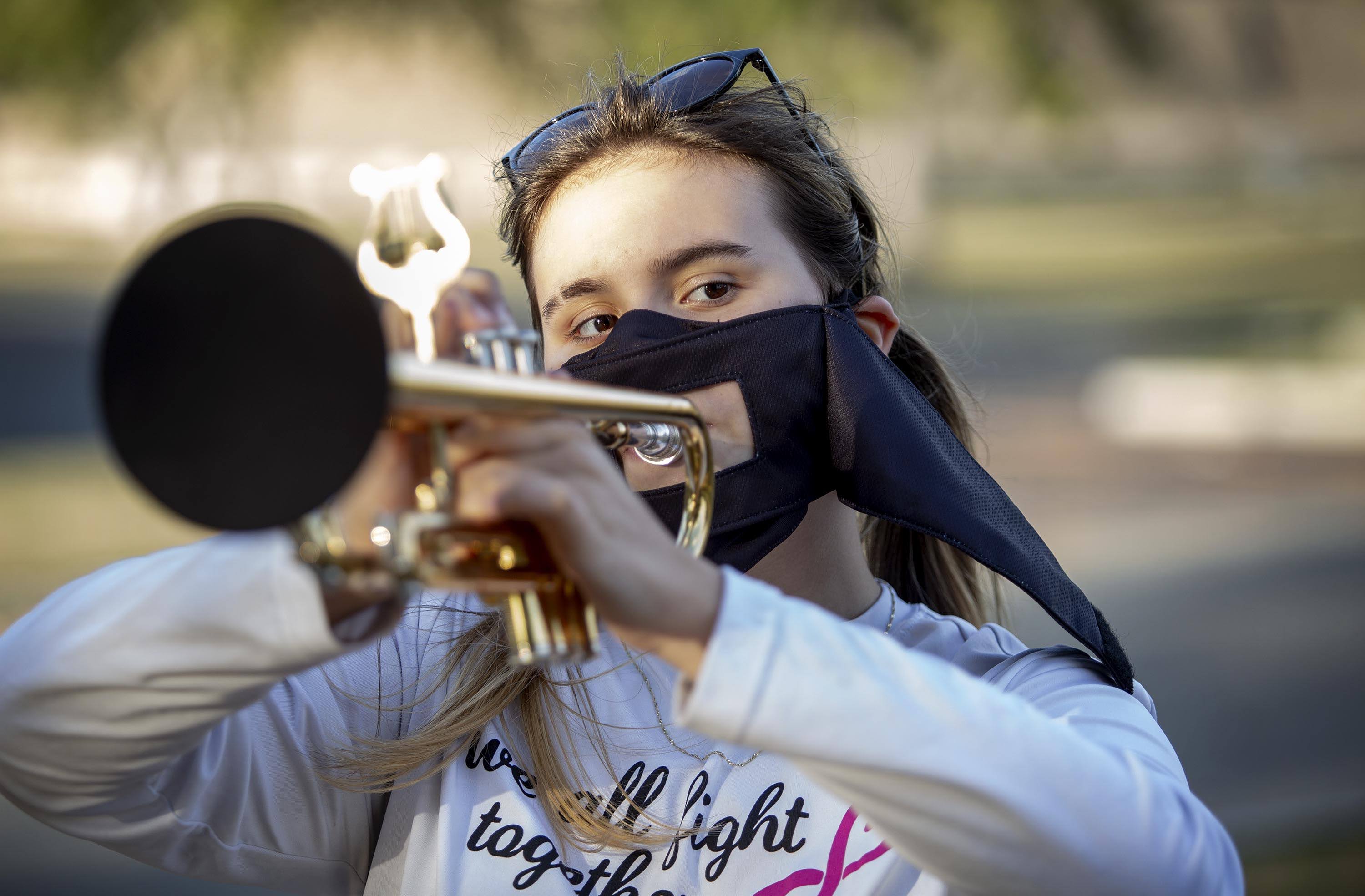 Makenna Calval, who plays for the High School Marching Band, has an adapted mask so she can play, and screen over the end of her trumpet to help prevent the possible spread of COVID-19. (Robin Lubbock/WBUR)
