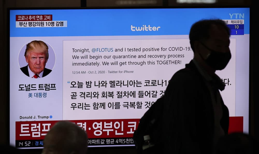 A man wearing a face mask walks near a TV screen showing an image of U.S. President Donald Trump's twitter during a news program at the Seoul Railway Station in Seoul, South Korea, Friday, Oct. 2, 2020. (Lee Jin-man/AP)