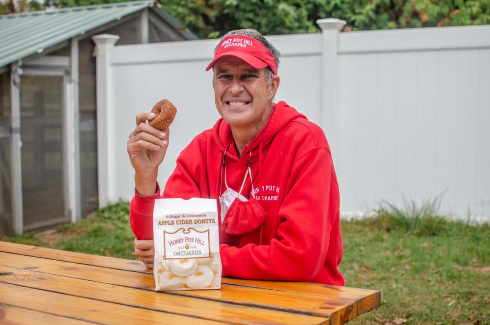 Andrew Martin, owner of Honey Pot Hill Orchards in Stow, Massachusetts, about to snack on cider doughnuts. (Sharon Brody/WBUR)