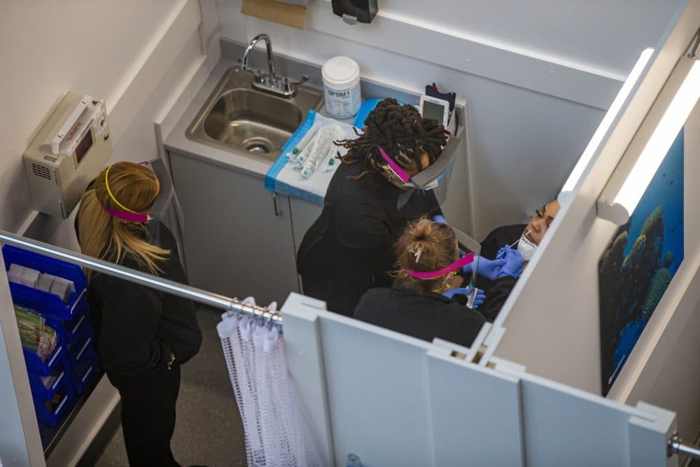 Medical assistant Aneka Gopaulsingh preforms a nasal swab test on a fellow employee at Logan Airport. (Jesse Costa/WBUR)