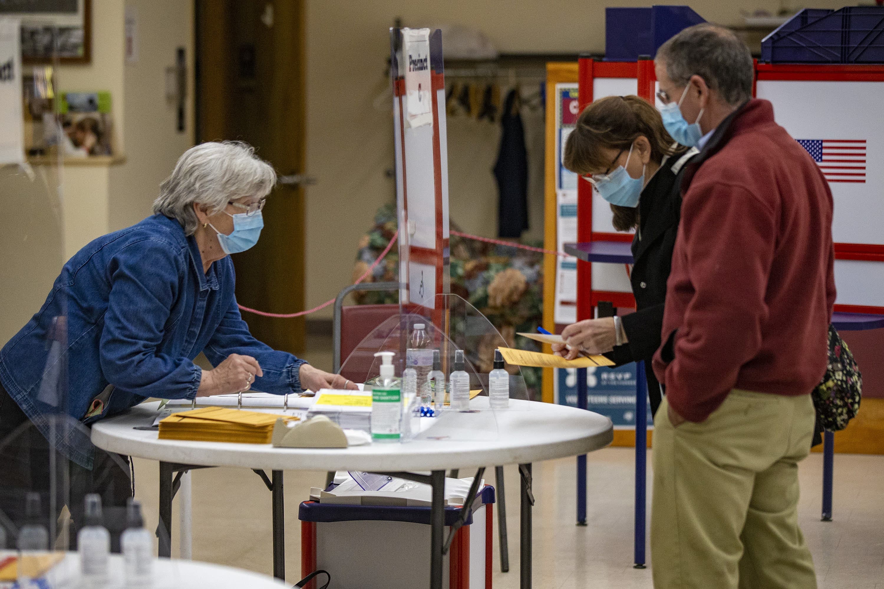 Patty and Peter Bonneau receives their ballots for early voting at a polling station inside the Ware Senior Center. (Jesse Costs/WBUR)