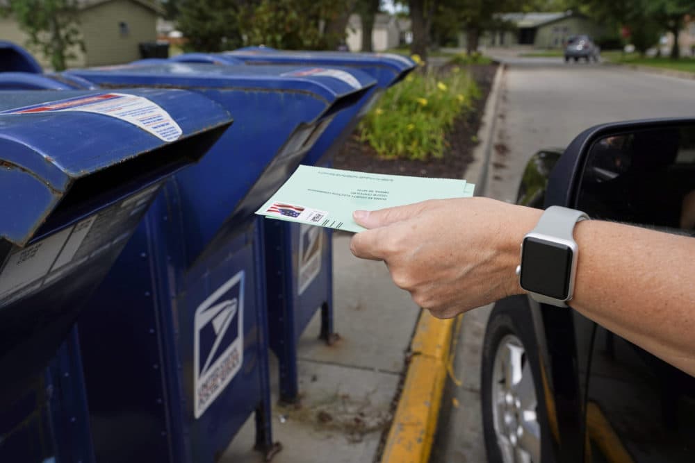 In this Aug. 18, 2020 photo, a person drops applications for mail-in-ballots into a mailbox in Omaha, Neb. U.S. (Nati Harnik/AP File)