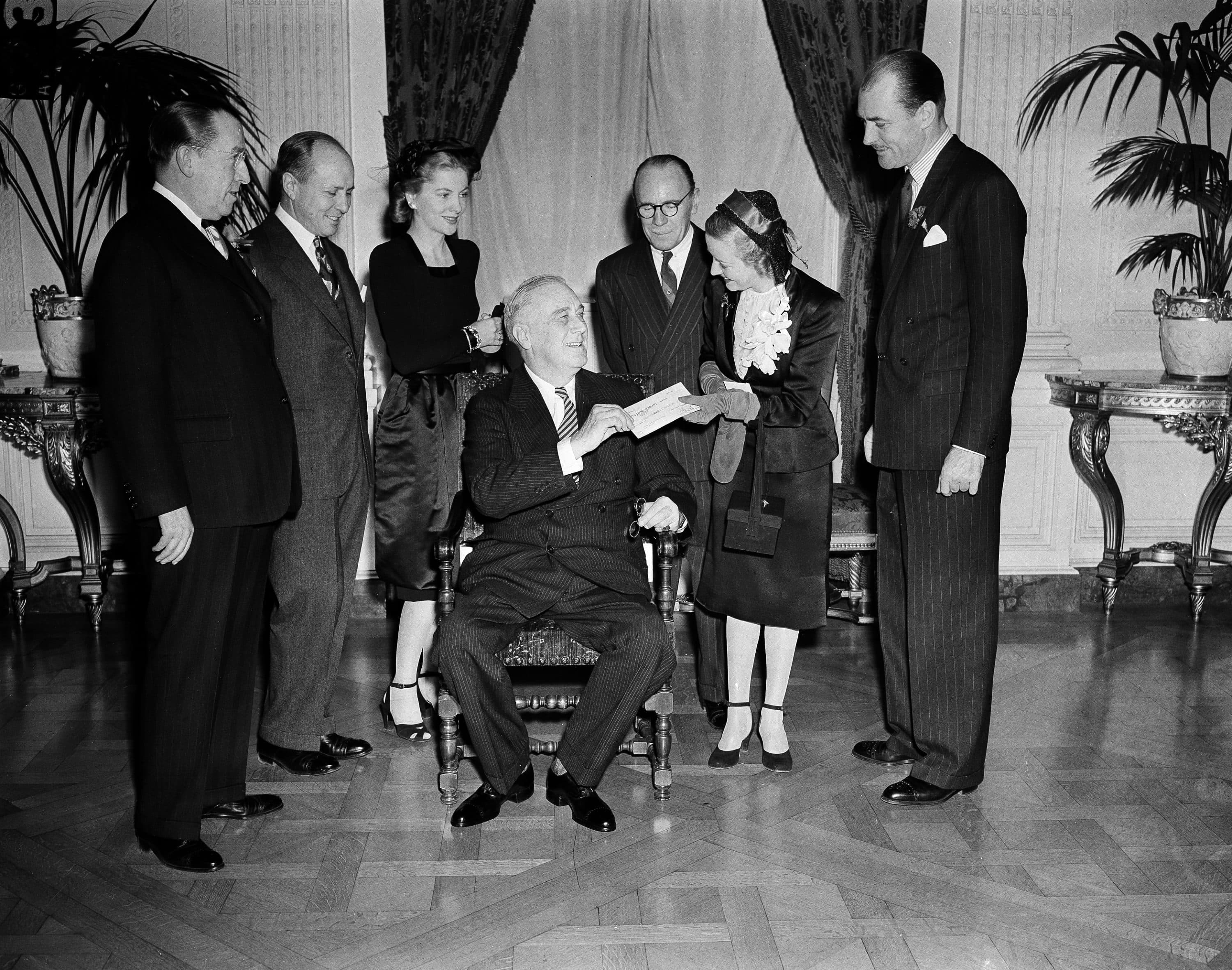 President Franklin D. Roosevelt, seated, receives a check for $240,000 from Lady Hardwicke at the Whtie House on Jan. 30, 1944, representing the major share of net profits from the motion picture "Forever and A Day," the money to aid in the fight against polio. (AP Photo/Eugene Abbott)