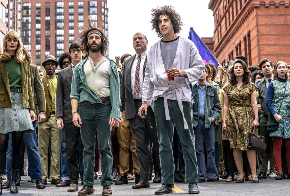 Left to right: Caitlin Fitzgerald, Alan Metoskie, Alex Sharp, Jeremy Strong, John Carroll Lynch, Sasha Baron Cohen and Noah Robbins in “The Trial of the Chicago 7.” (Courtesy Niko Tavernise/Netflix)