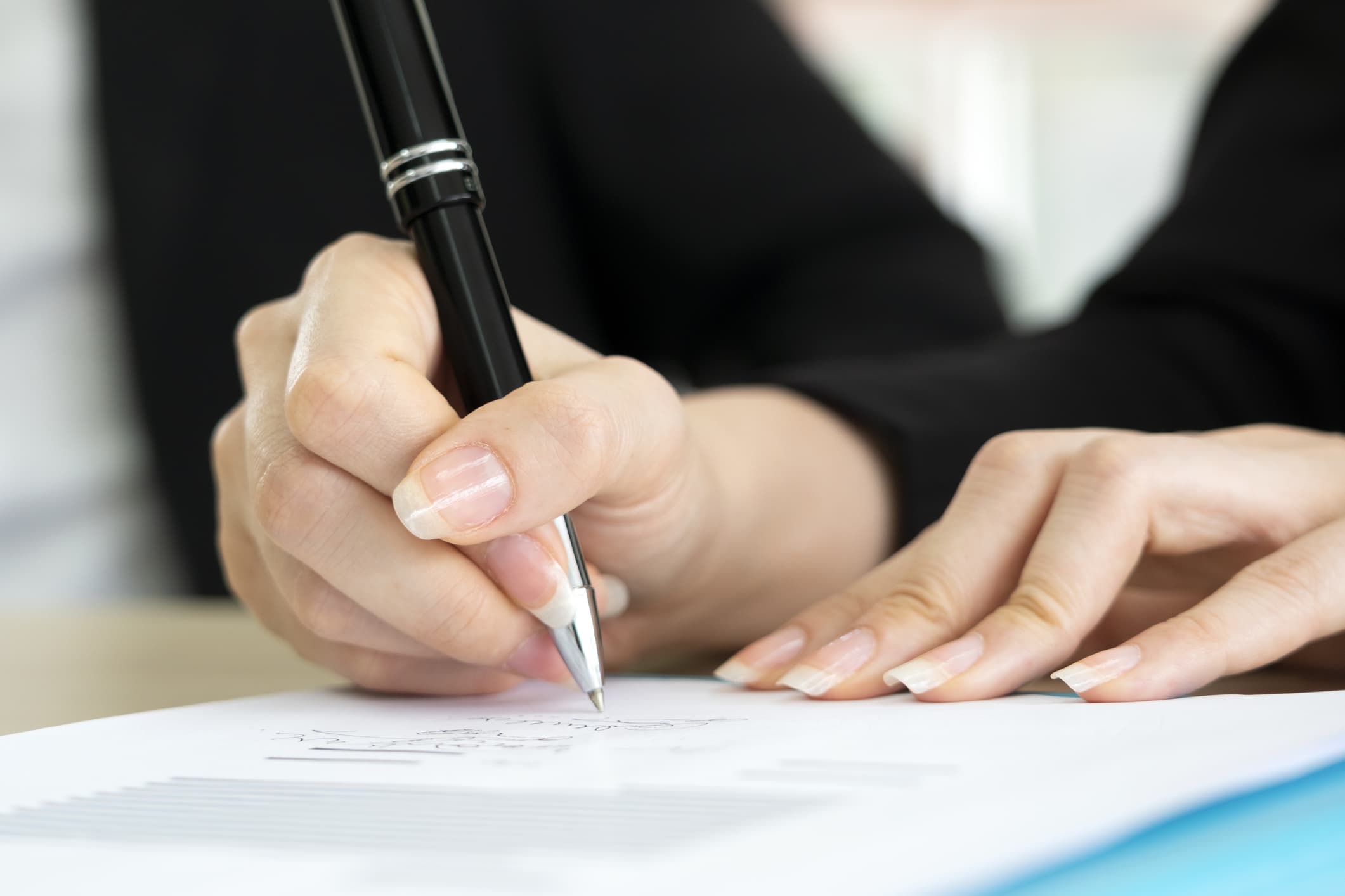 Business woman signing the contract to conclude a deal.