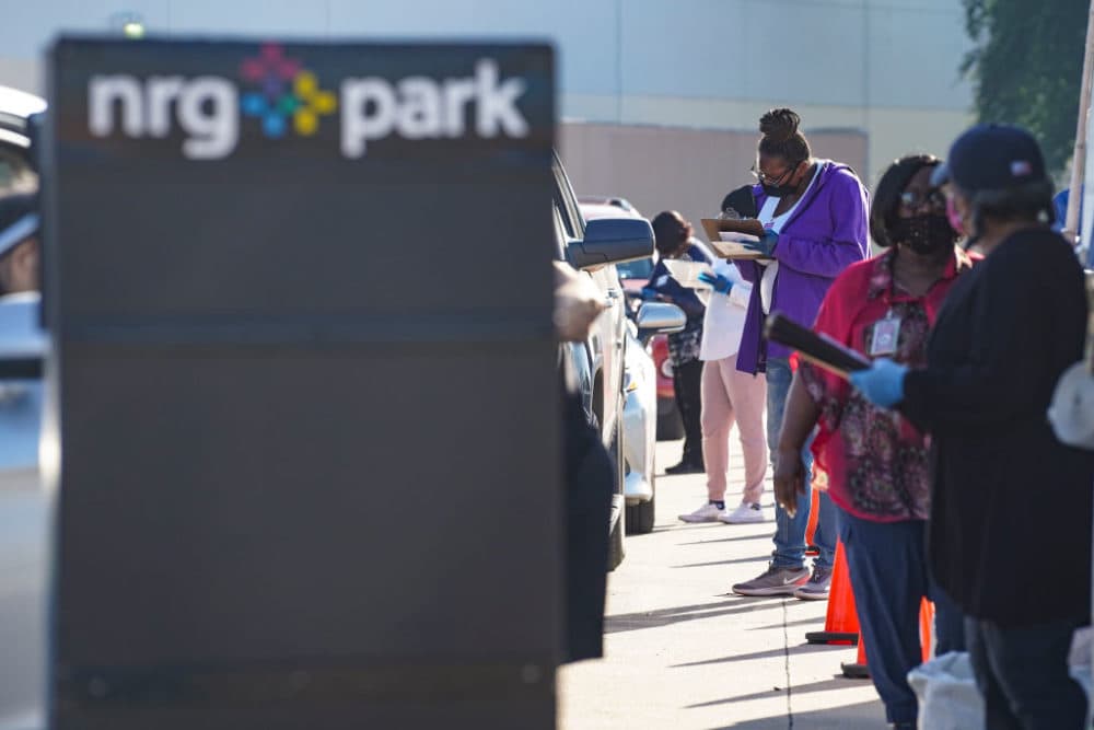 Election workers accept mail in ballot from voters at drive-through mail ballot drop off site at NRG Stadium on October 7, 2020 in Houston, Texas. Gov. Gregg Abbott  issued an executive order limiting each Texan county to one mail ballot drop-off site. (Go Nakamura/Getty Images)