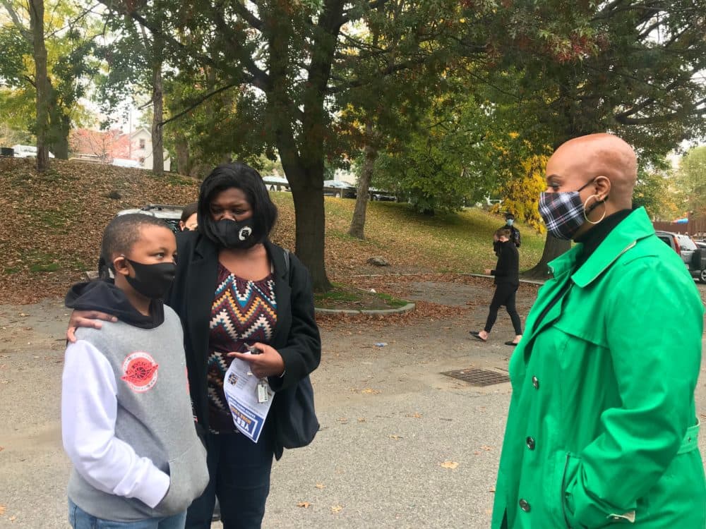 Congresswoman Ayanna Pressley (right) speaks with 9-year-old Zion Rodriguez (left) and his nana, Debra Groomes (middle) outside the Shelburne Community Center in Roxbury. (Quincy Walters/WBUR)