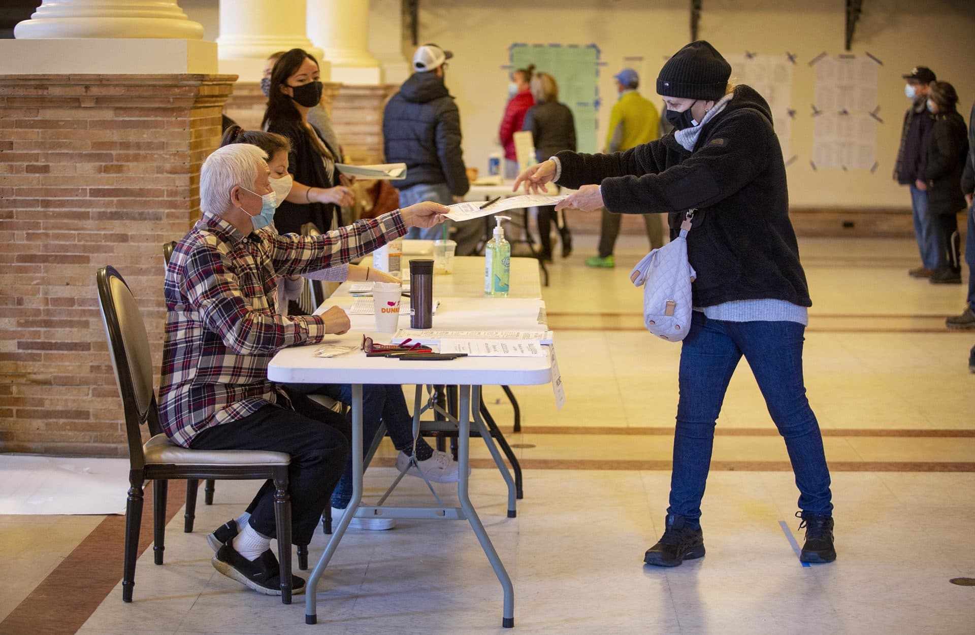 A voter keeps social distancing in mind as she picks up her ballot at the Boston Public Library. (Robin Lubbock/WBUR)