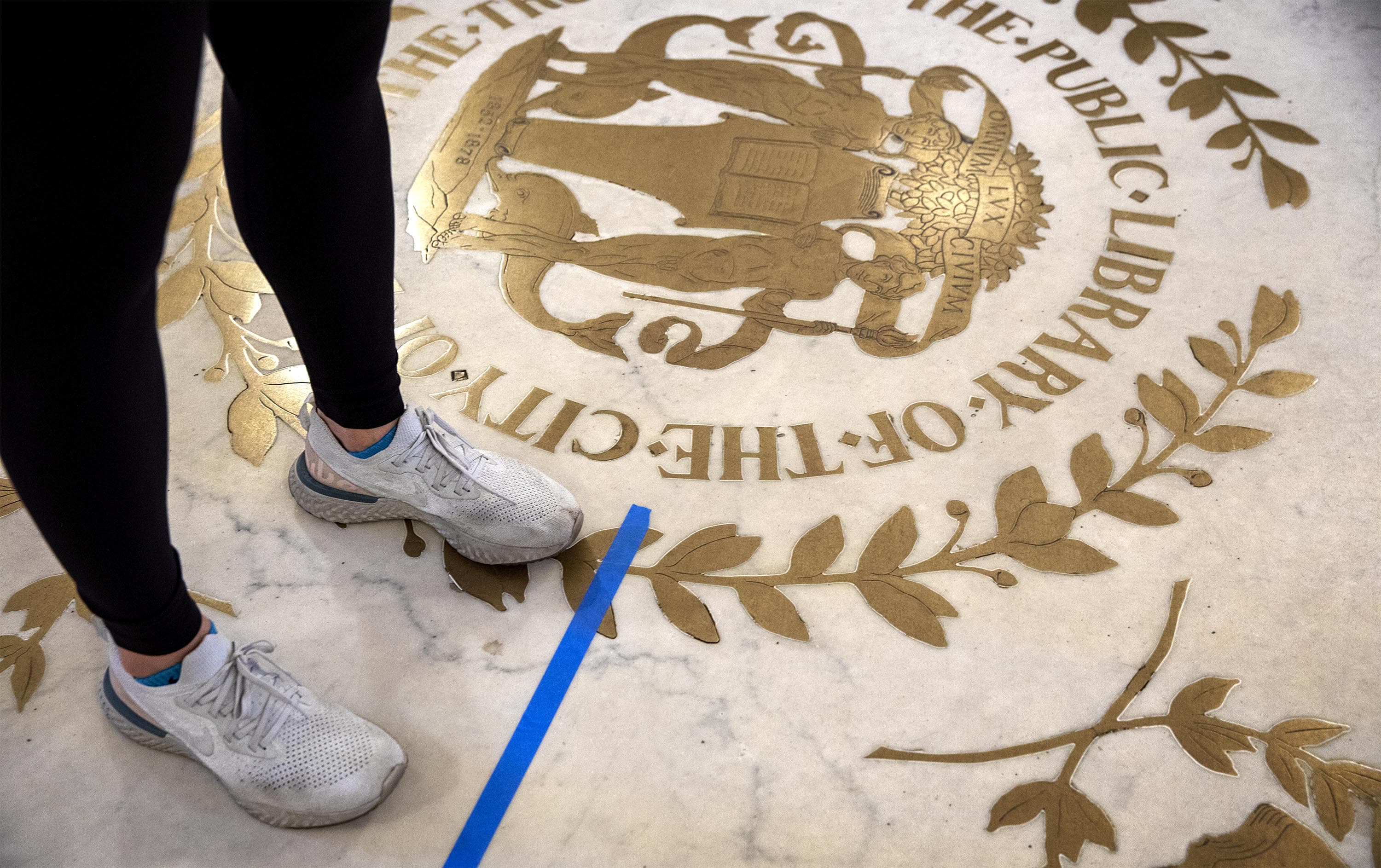 Voters wait in line at social distancing marks in the hallways of the Boston Public Library. (Robin Lubbock/WBUR)