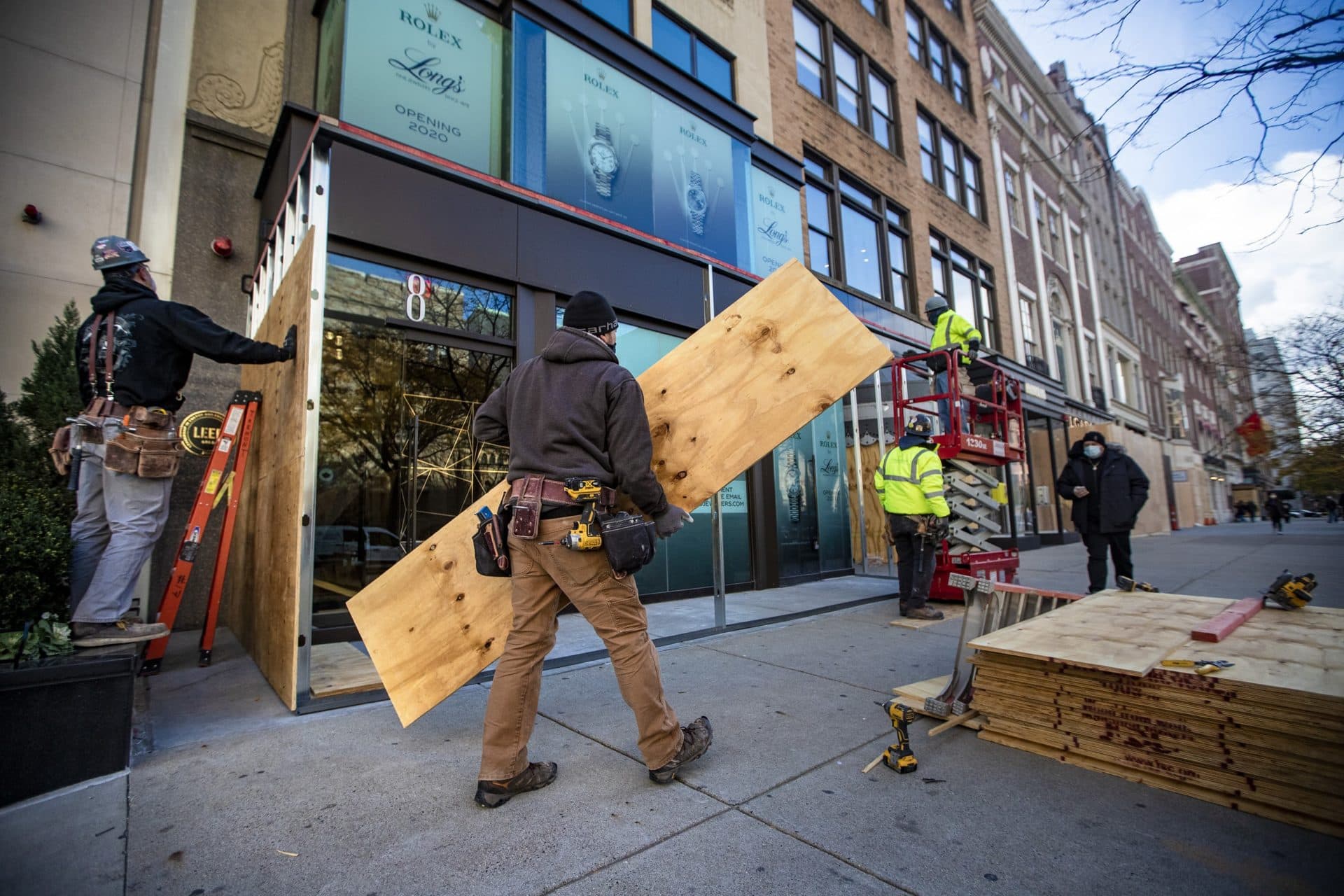 Contractors install a plywood frame around the entrance of Long’s Jewelers on Newbury Street in case of potential Election Night vandalism. (Jesse Costa/WBUR)