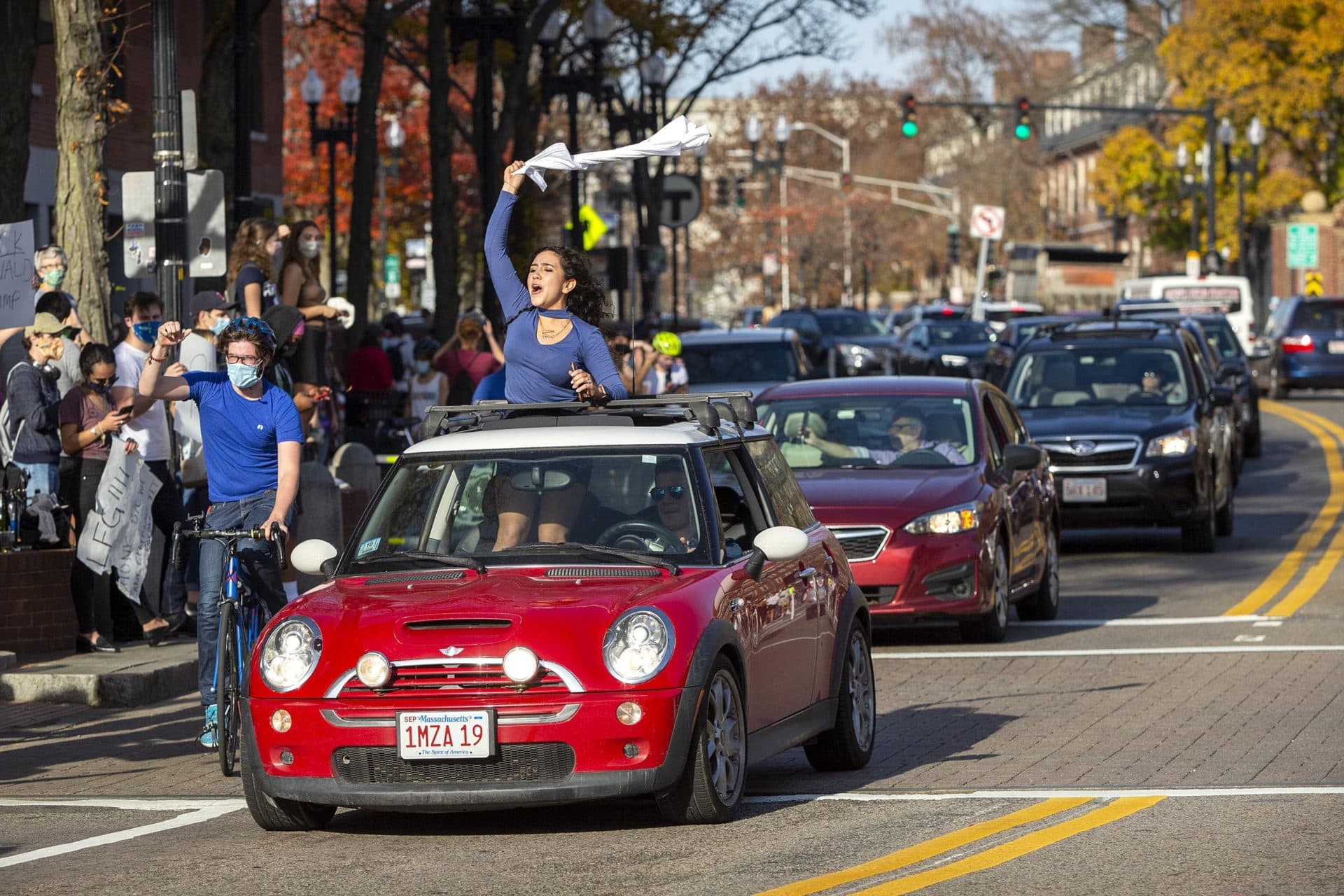 Cars honk their horns for the cheering crowd in Harvard Square. Many were out celebrating Joe Biden's victory. (Robin Lubbock/WBUR)