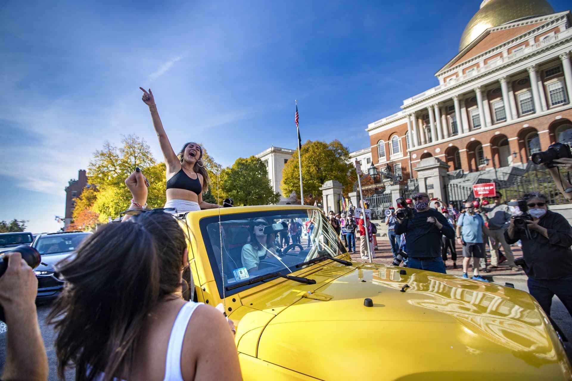 People in cars passing by a Trump rally celebrate the Joe Biden presidential election win. (Jesse Costa/WBUR)