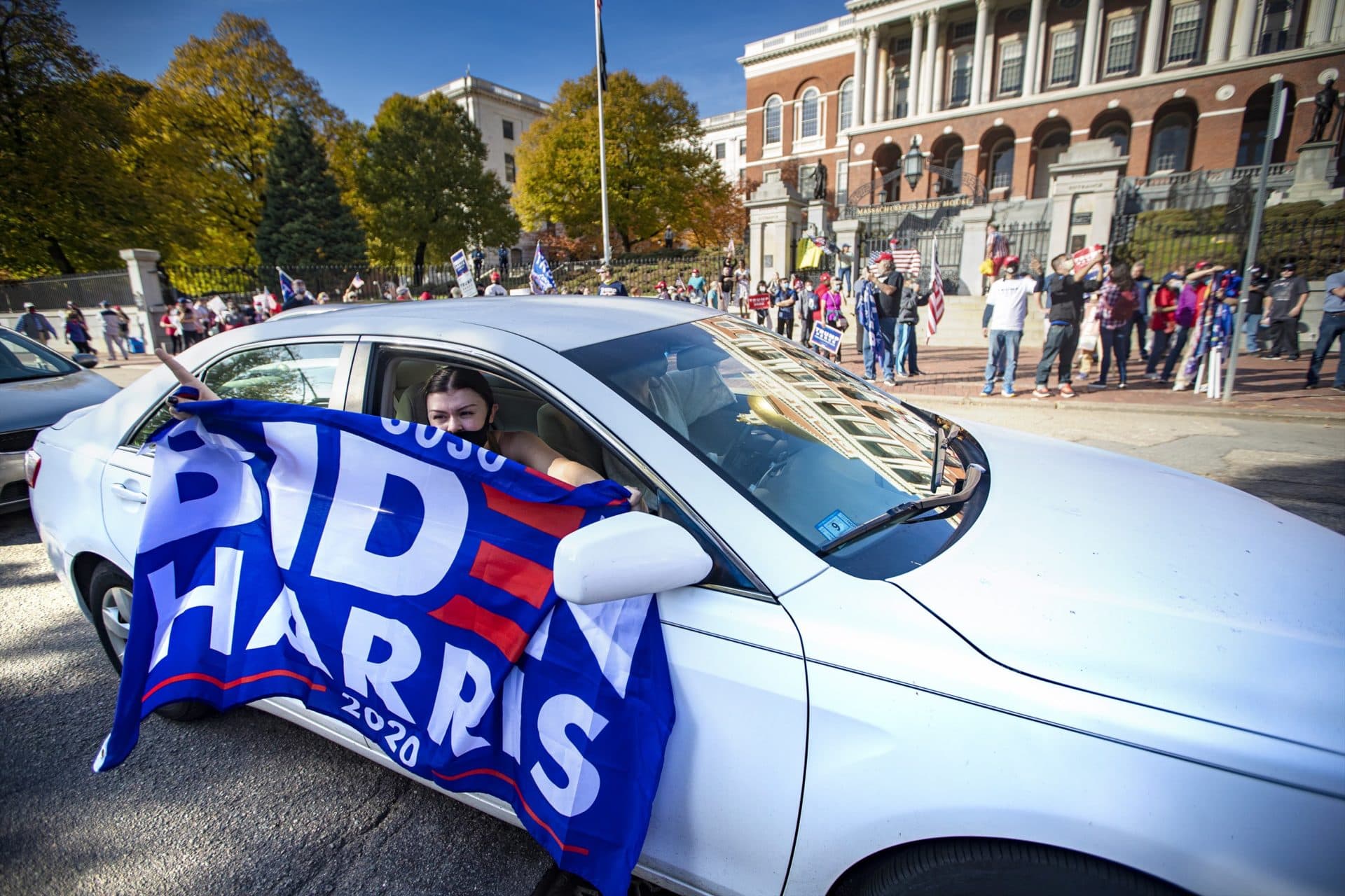 People in cars passing by a Trump rally celebrate the Joe Biden presidential election win. (Jesse Costa/WBUR)