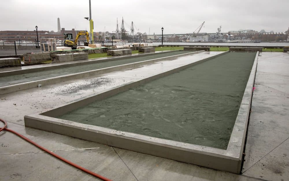 A bocce court under construction at Langone Park, looking across the harbor to Bunker Hill and USS Constitution. (Robin Lubbock/WBUR)