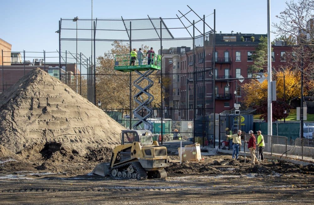 Construction crews work on one of the baseball fields at Langone Park. (Robin Lubbock/WBUR)