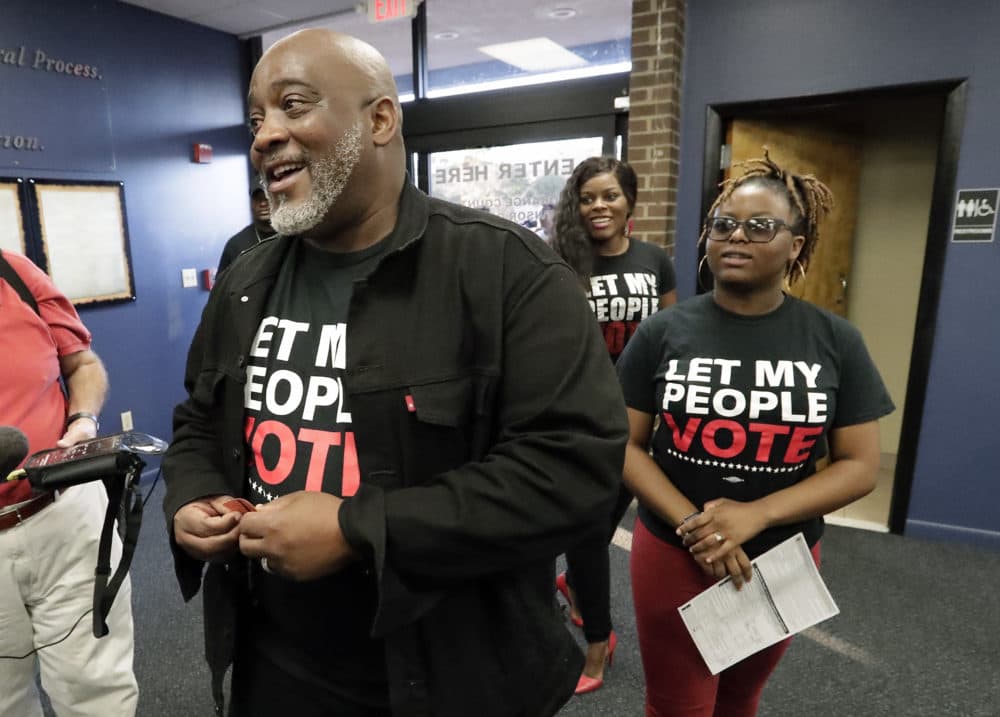 Desmond Meade (left), a former felon and president of the Florida Rights Restoration Coalition, arrives with family members at the Supervisor of Elections office on Jan. 8, 2019, in Orlando, Florida, to register to vote. (John Raoux/AP)