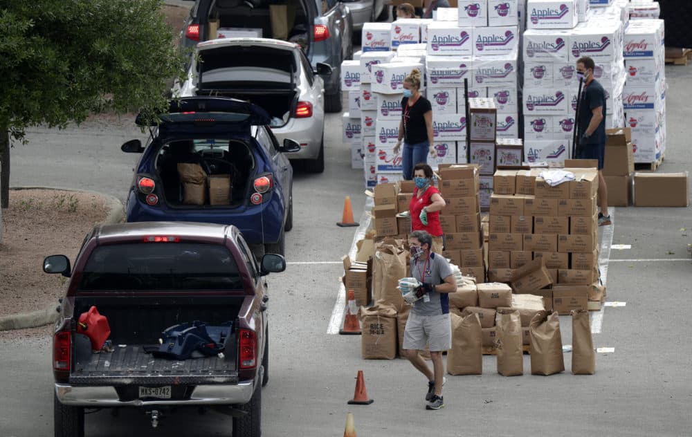 Workers and volunteers help load cars with food at a San Antonio Food Bank drive-through distribution during the coronavirus pandemic in San Antonio, Tuesday, April 7, 2020. (Eric Gay/AP)