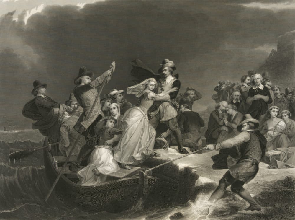 This circa 1869 engraving titled &quot;Landing of the Pilgrims on Plymouth Rock, 1620&quot; made available by the Library of Congress depicts a woman being helped ashore from a small boat held in position against a rock by men with ropes and poles. At background right, other Pilgrims kneel in prayer. (Peter Frederick Rothermel, Joseph Andrews/Library of Congress via AP)