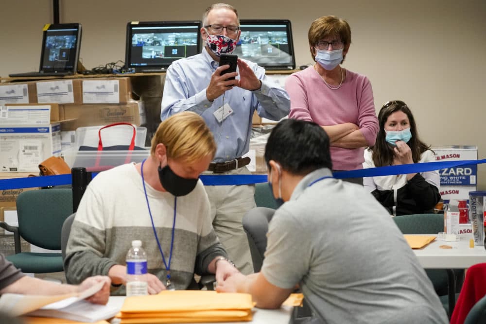 Republican canvas observer Ed White, and Democratic canvas observer Janne Kelhart, watch as Lehigh County workers count ballots as vote counting in the general election on Friday, Nov. 6, 2020, in Allentown, Pennsylvania. (Mary Altaffer/AP)
