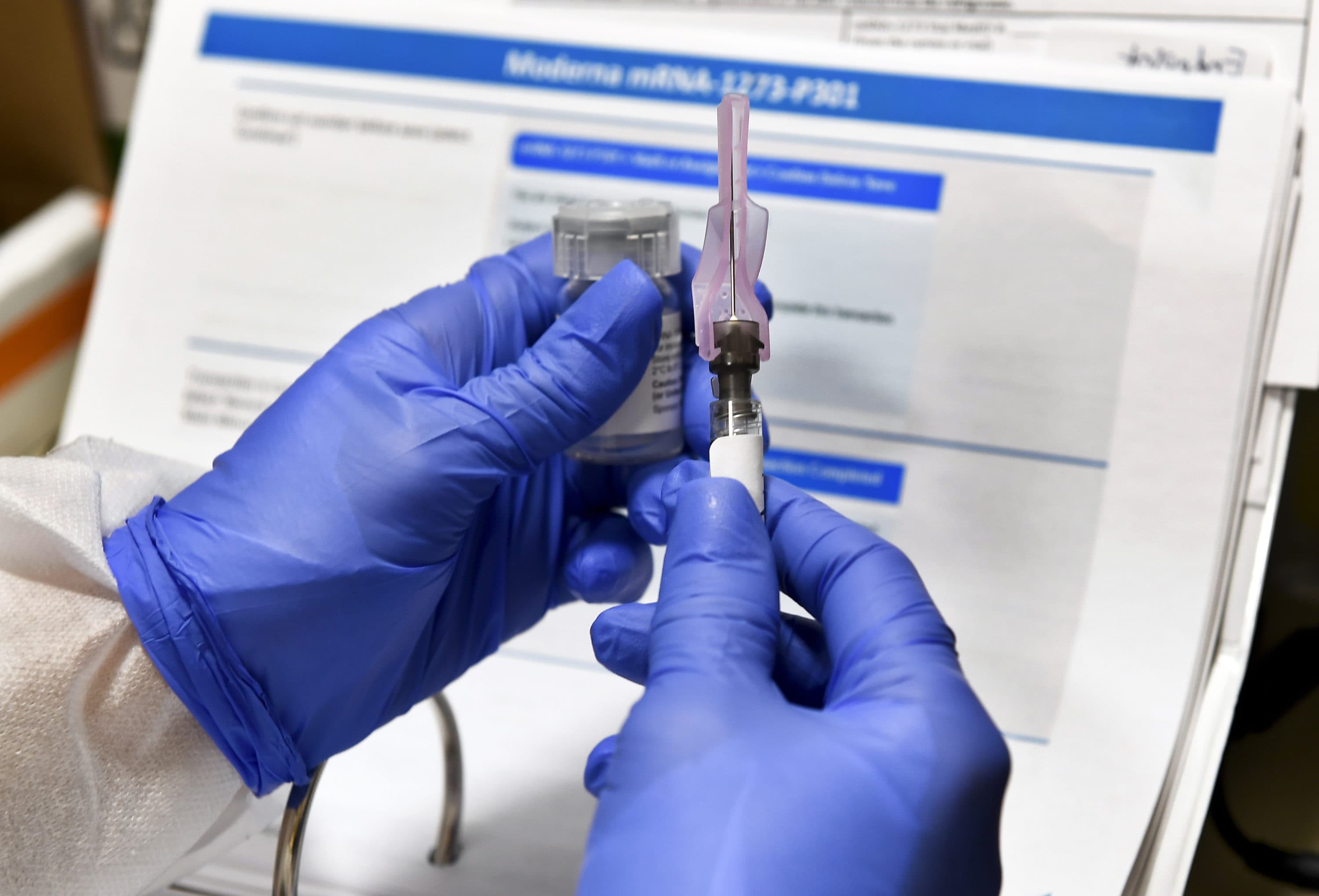 In this July 27, 2020, file photo, nurse Kathe Olmstead prepares a shot that is part of a possible COVID-19 vaccine, developed by the National Institutes of Health and Moderna Inc., in Binghamton, N.Y. (Hans Pennink/AP File)