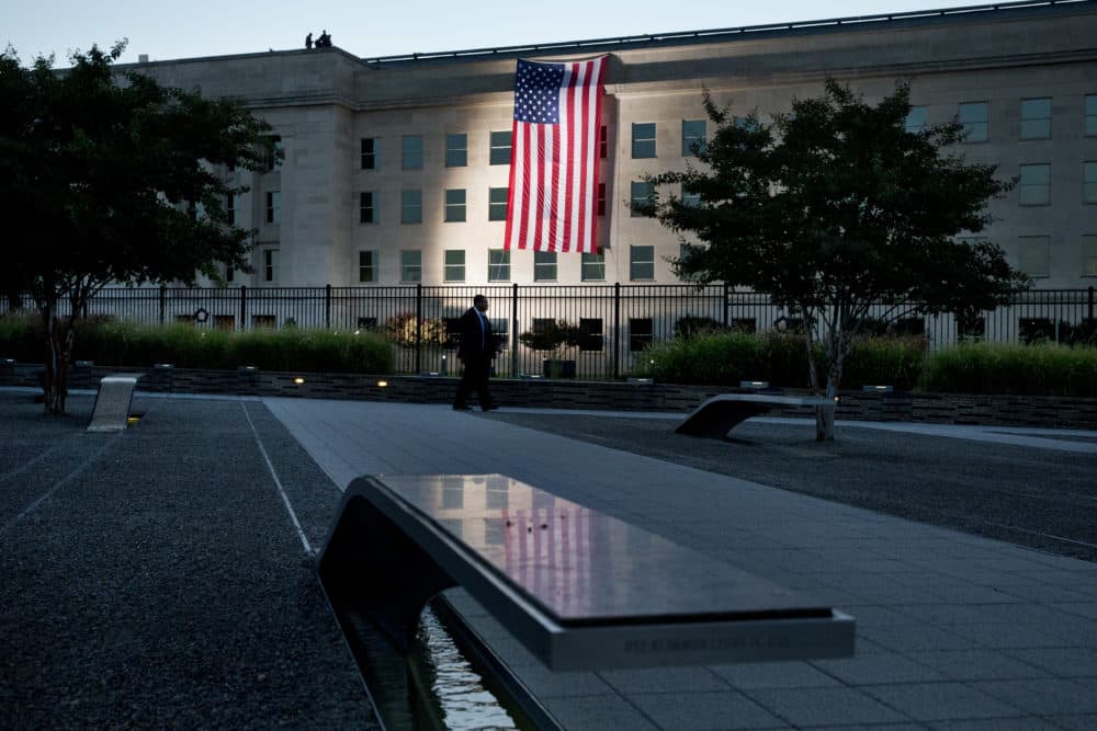 As seen from the Pentagon Memorial, a U.S. flag is draped on the side of the Pentagon where the building was attacked on Sept. 11 in 2001, on the 14th anniversary of the attack, Friday Sept. 11, 2015, in Washington. (Jacquelyn Martin/AP)