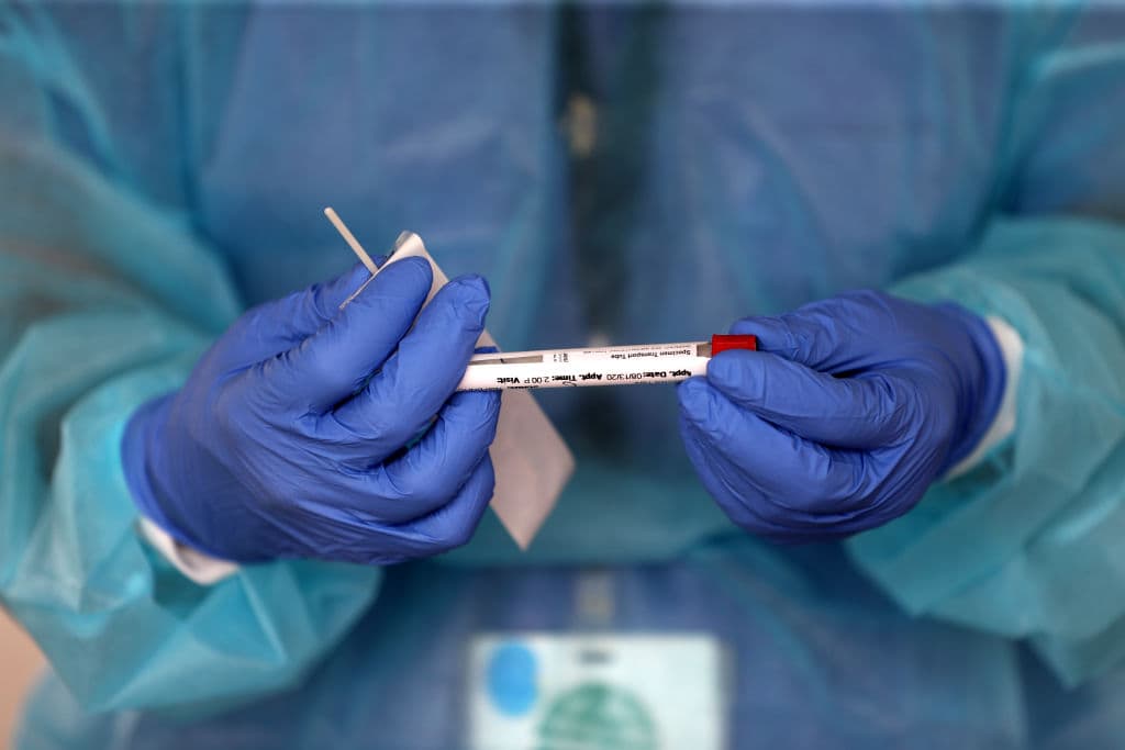 A nurse practitioner administers COVID-19 tests in a parking lot in Brockton, Massachusetts. (David L. Ryan/The Boston Globe via Getty Images)