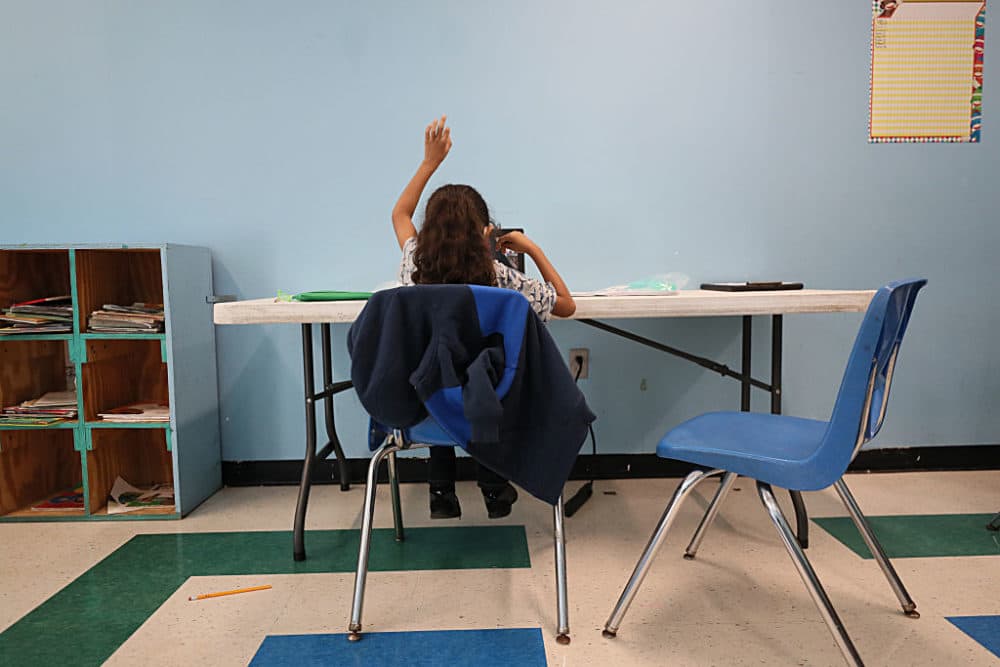 A student raises her hand in her virtual classroom at the Roxbury YMCA in Boston on Sept. 21, 2020. (Suzanne Kreiter/The Boston Globe via Getty Images)