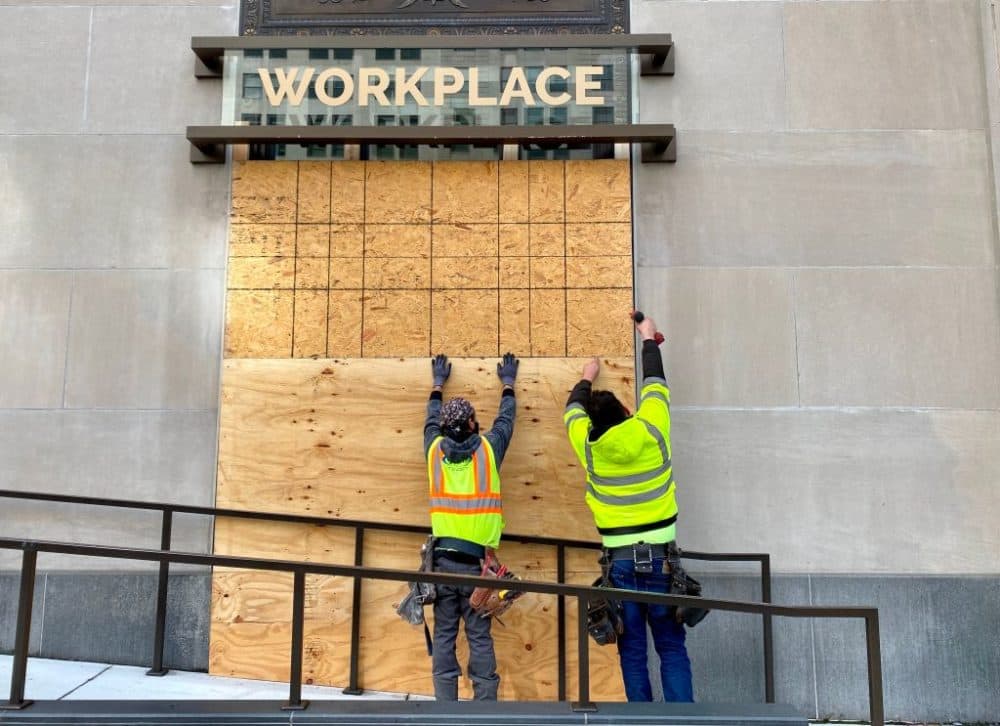 Workers board up a business in Washington, DC, on October 30, 2020, four days before the US presidential election, as businesses fear post-electoral violence. (Daniel Slim/AFP via Getty Images)