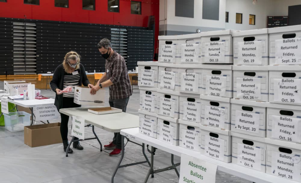 Poll workers Angela and Zach Achten check-in a box of absentee ballots in the gym at Sun Prairie High School on November 3, 2020 in Sun Prairie, Wisconsin. (Andy Manis/Getty Images)