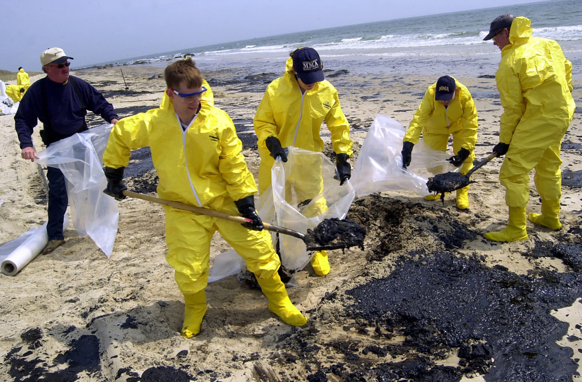 DARTMOUTH, MA - April 29: Personnel with Clean Harbors Inc. remove oil from Barneys Joy beach April 28, 2003 in Dartmouth, Massachusetts. On April 27, 2003 an oil barge developed a leak in Buzzards Bay, spilling at least 14,000 gallons of #6 fuel oil into the bay. U.S. Coast Guard and environmental clean-up crews are attempting to contain the spill in coastal areas of southeastern Massachusetts and Rhode Island. (Photo by Douglas McFadd/Getty Images)