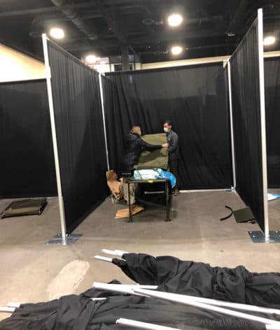 Workers set up hospital beds at the field hospital operating in the DCU Center in Worcester on April 1. (Deborah Becker/WBUR)