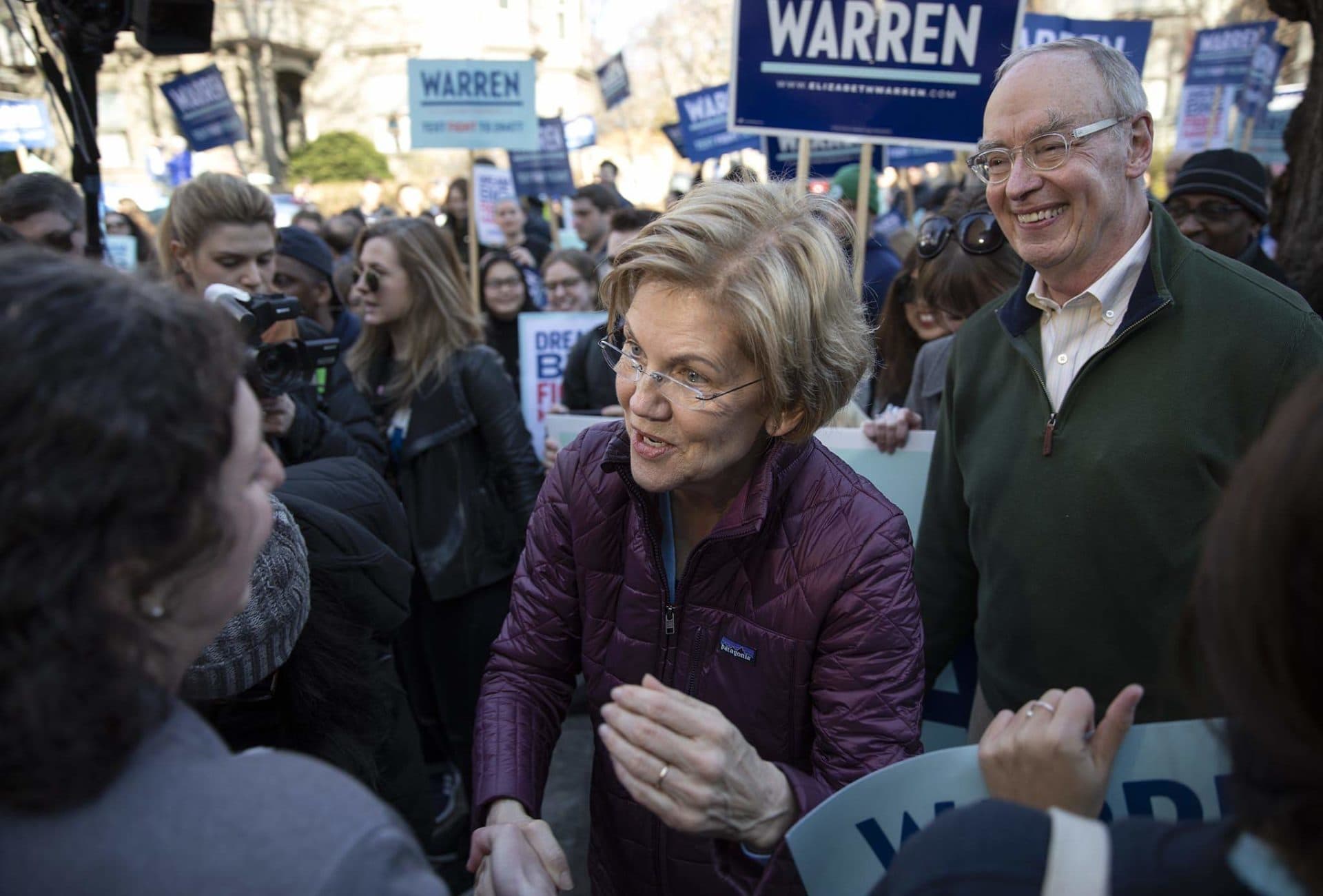 Sen. Elizabeth Warren and her husband Bruce Mann greet supporters on their way to vote in Cambridge, Mass.. (Robin Lubbock/WBUR)