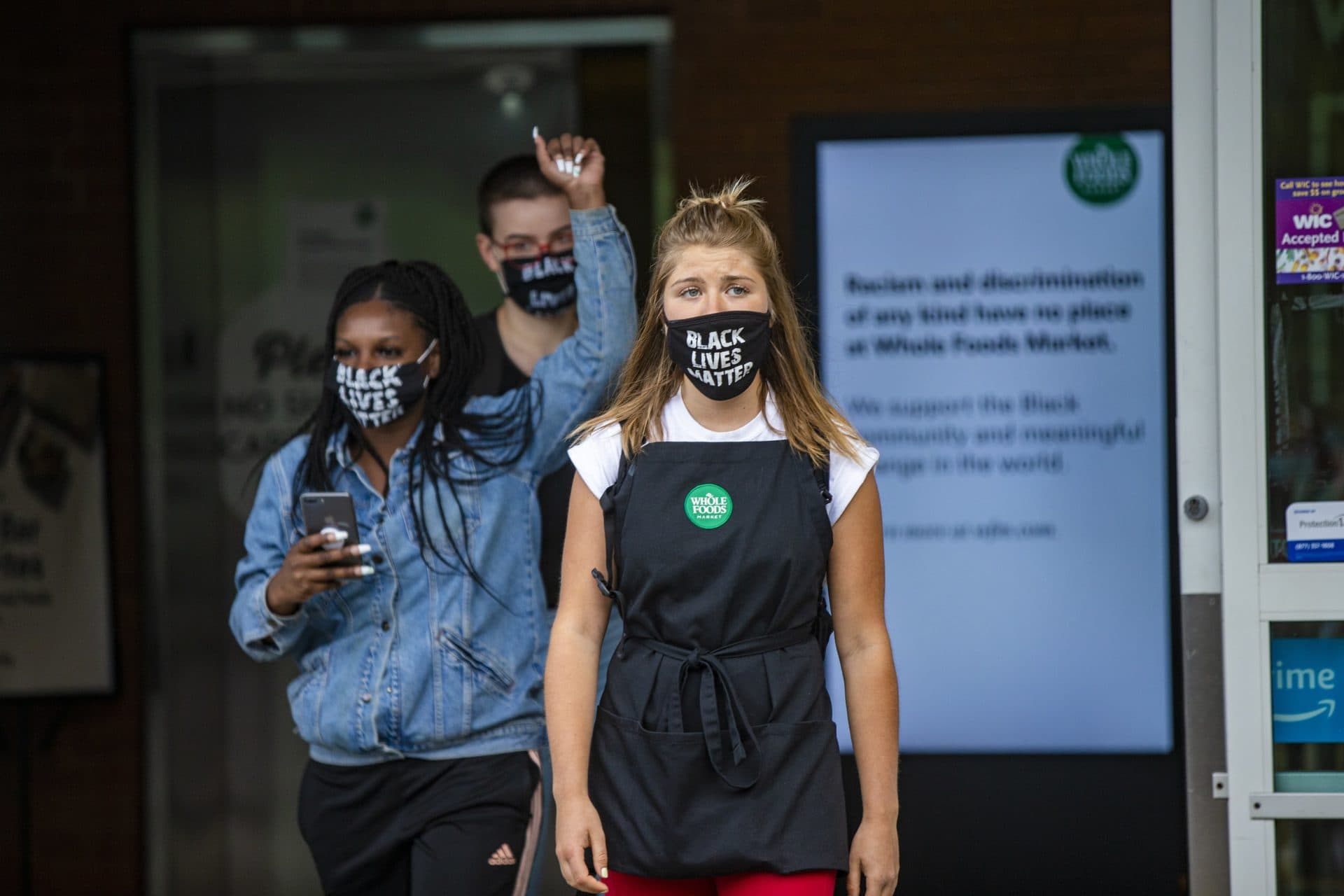 Action organizer Savannah Kinzer leads a group of other employees dismissed by managers for wearing Black Lives Matter masks during their shifts at Whole Foods on River Street in Cambridge. (Jesse Costa/WBUR)