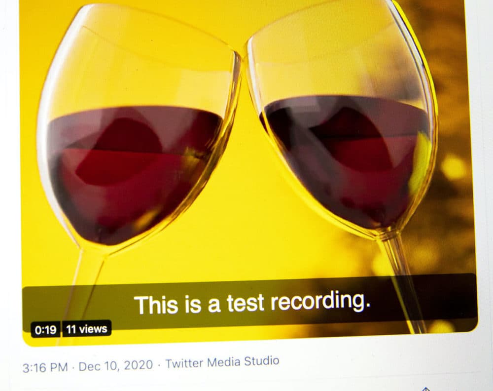 A captioned Twitter video of two wine glasses clinking.