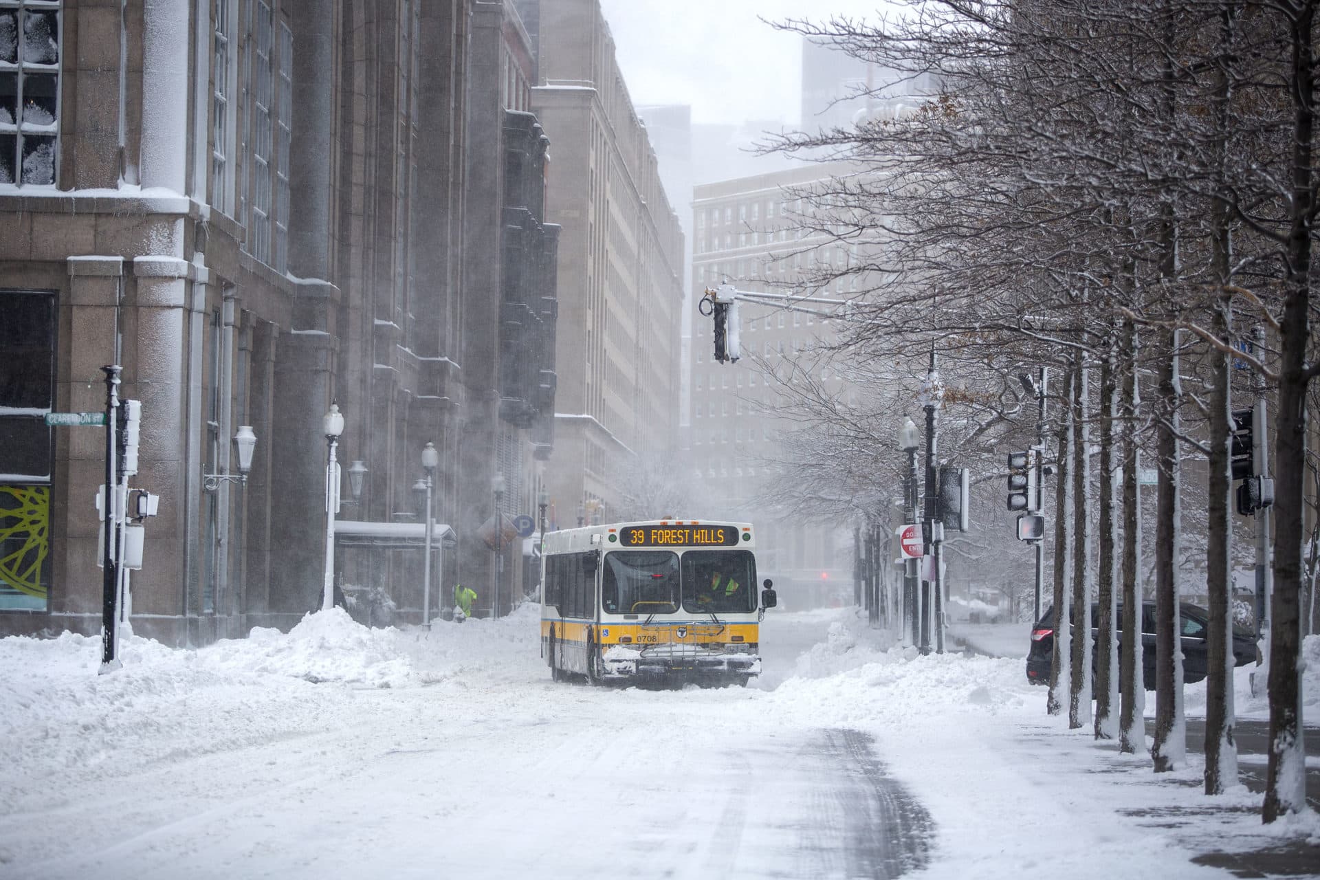 A bus moves through downtown Boston during a December snowstorm. (Robin Lubbock/WBUR)
