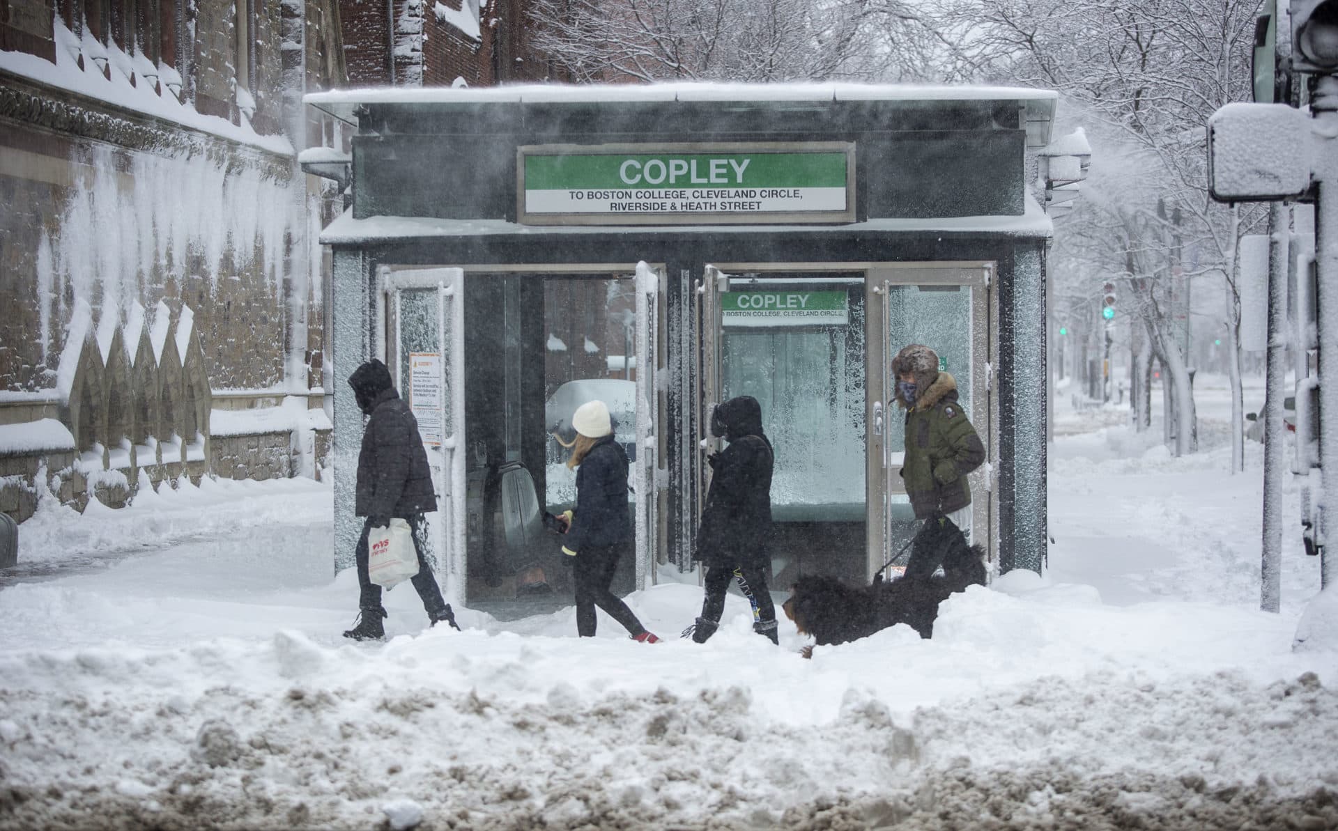 Snow blows off the roof of the entrance to the Copley MBTA station, as the storm comes to an end. (Robin Lubbock/WBUR)