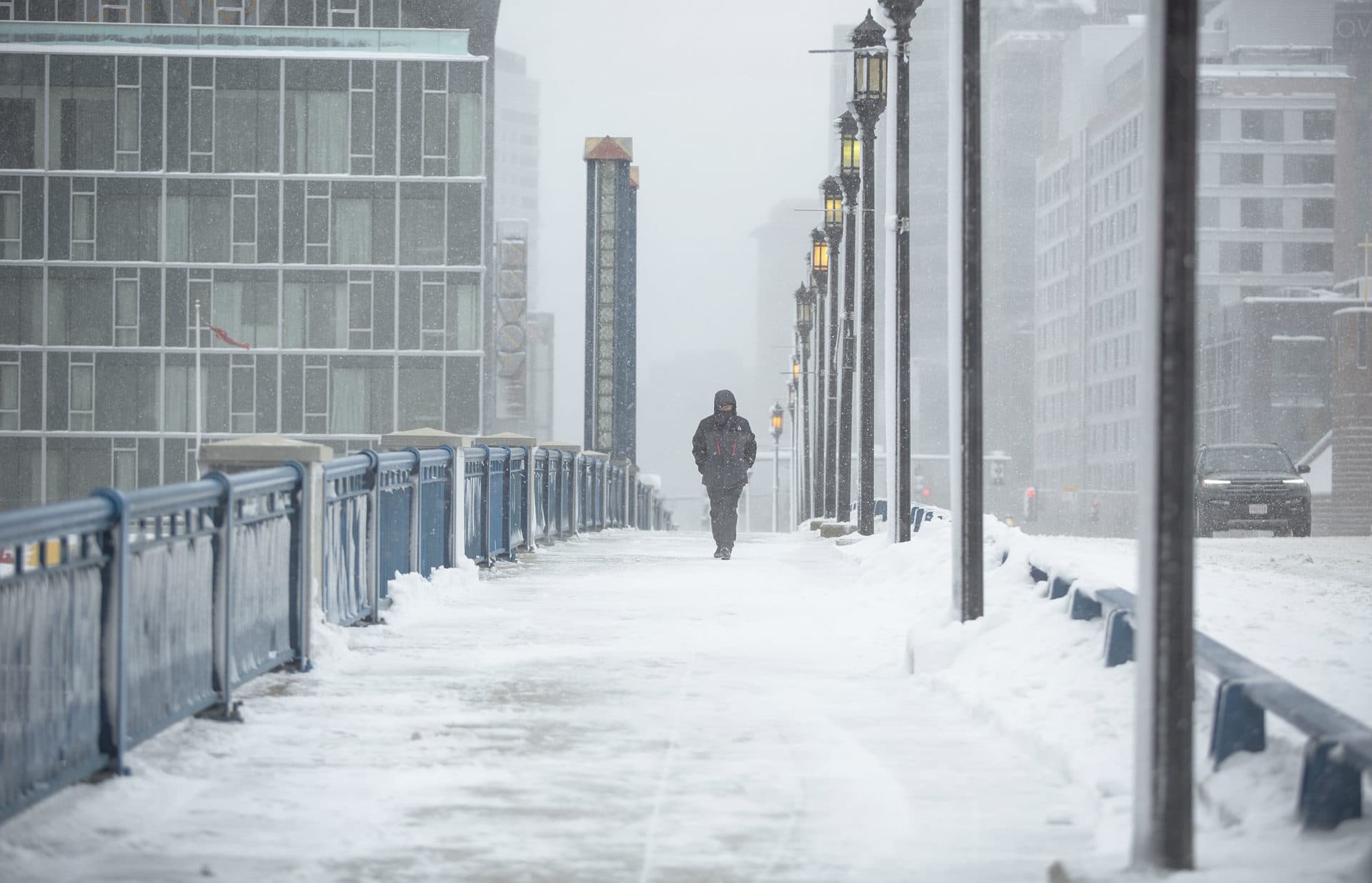 A pedestrian walks over Seaport Boulevard bridge as the storm winds down. (Robin Lubbock/WBUR)