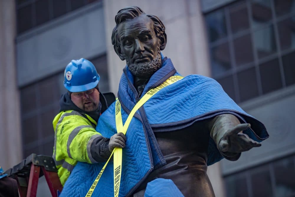 Workers tie down the 2,800-lb. statue of Lincoln onto a flat bed truck. (Jesse Costa/WBUR)