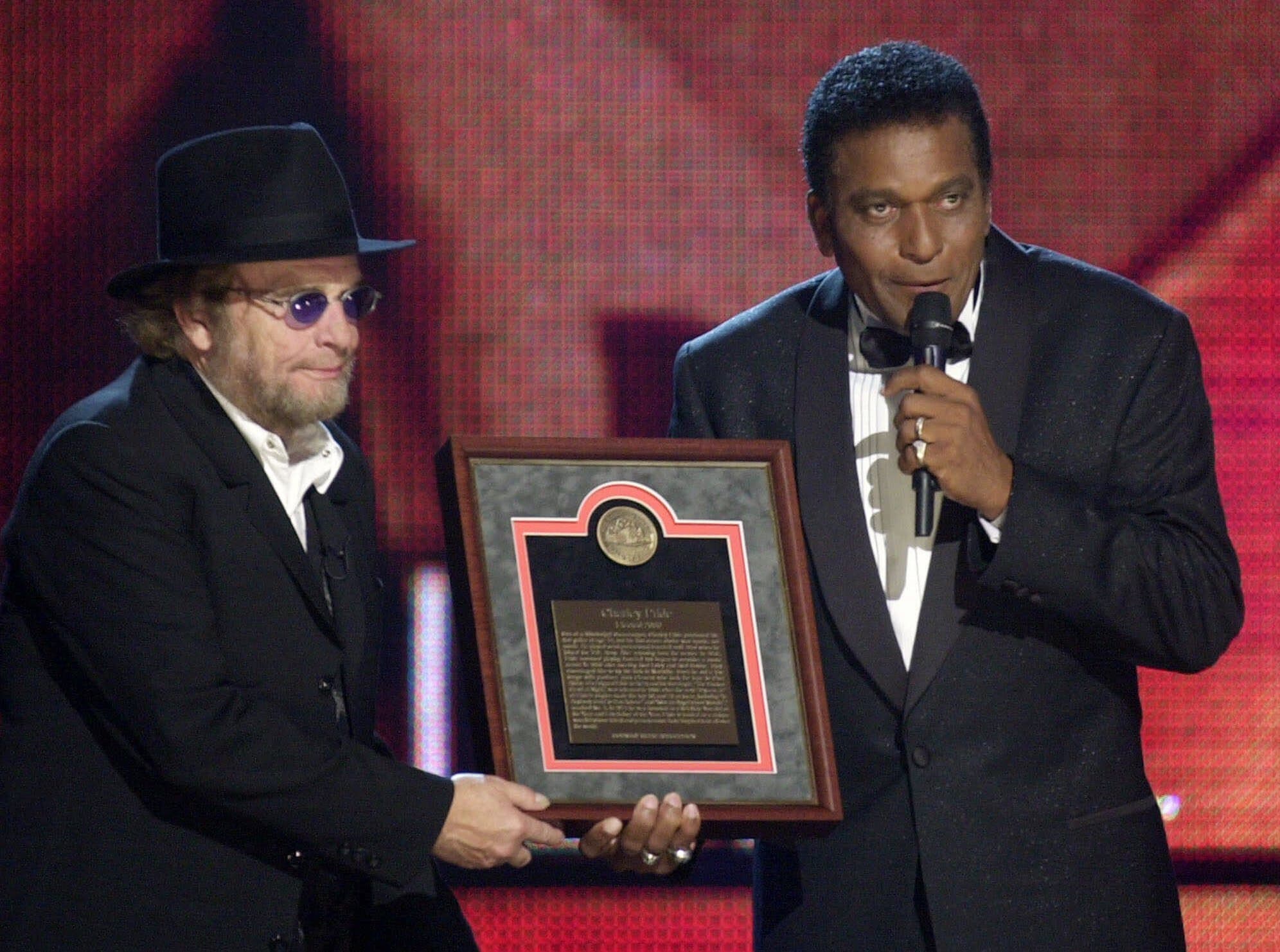 In this Oct. 4, 2000, photo, Charley Pride, right, receives his Country Music Hall of Fame plaque from Merle Haggard at the Country Music Association Awards show at the Grand Ole Opry House in Nashville, Tenn. (Charlie Neibergall/AP)