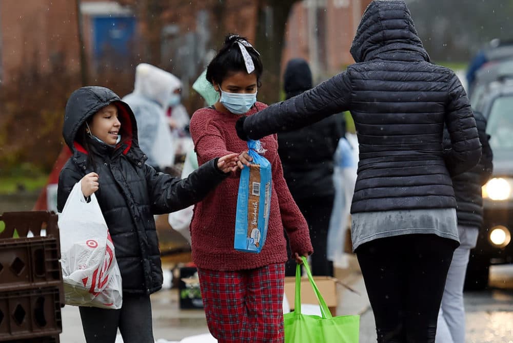 Volunteers from the Baltimore Hunger Project pass out food to people in need outside of Padonia International Elementary school on December 4, 2020 in Cockeysville, Maryland. (OLIVIER DOULIERY/AFP via Getty Images)