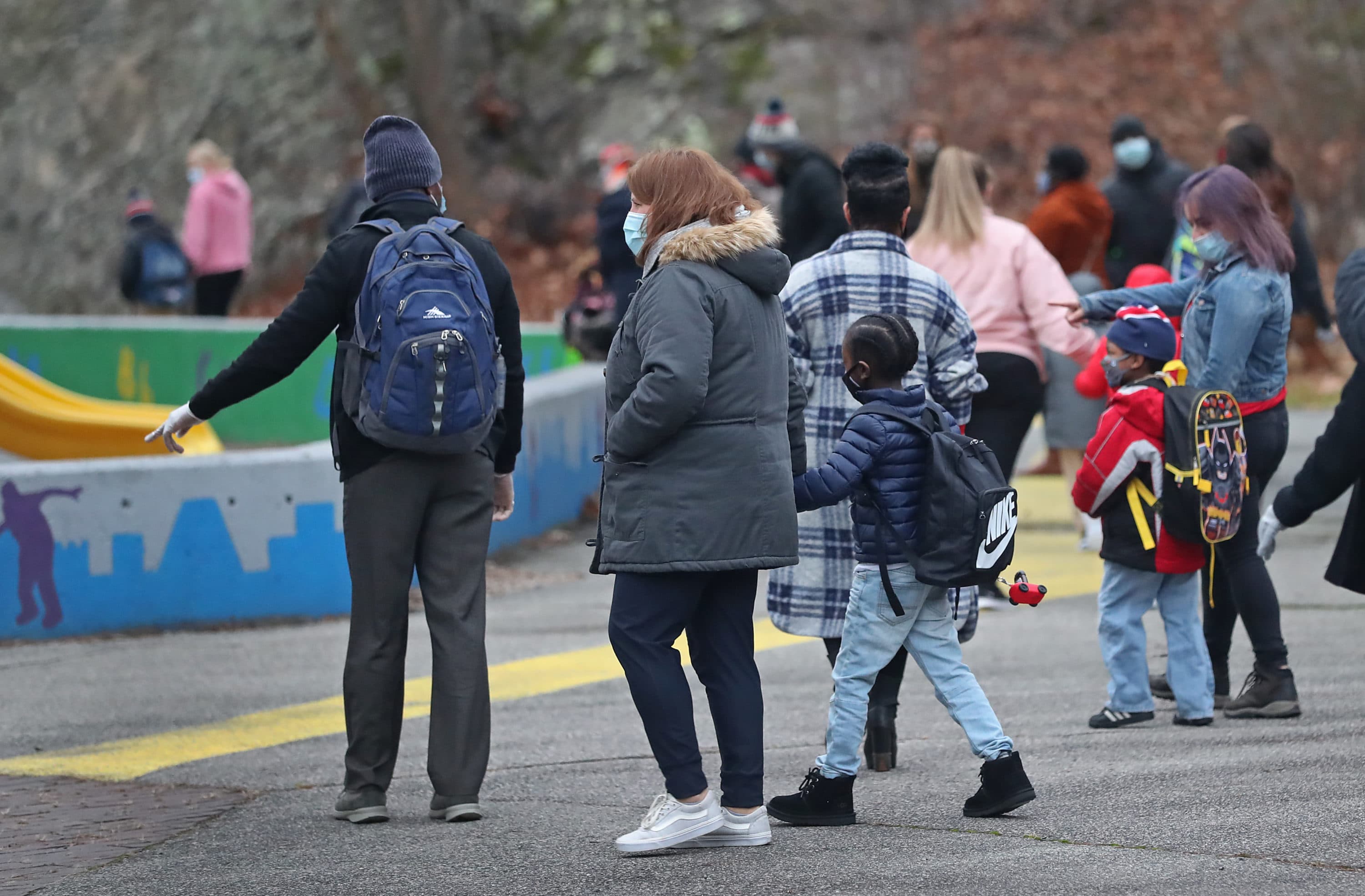 Teachers and students walk to the entrance at the Mattahunt Elementary School in Boston's Mattapan before the day's start on Dec. 14, 2020. (David L. Ryan/The Boston Globe via Getty Images)