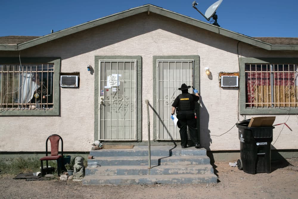 A Maricopa County constable knocks on a door before posting an eviction order on Oct. 1, 2020 in Phoenix, Arizona. (John Moore/Getty Images)
