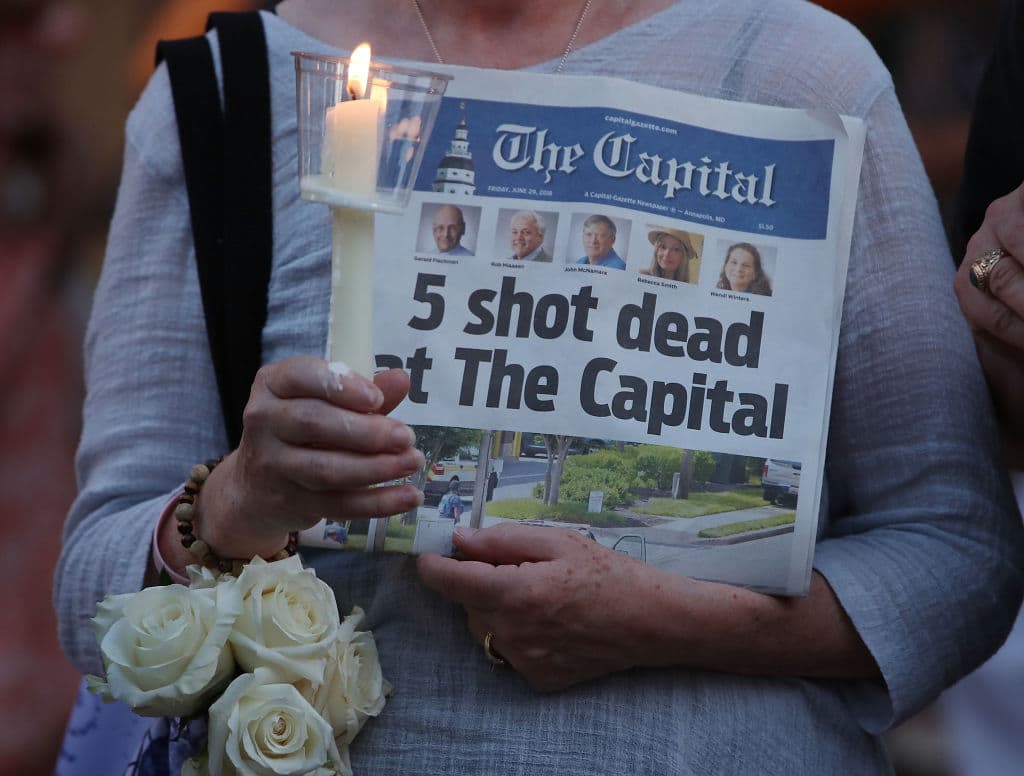 A women holds an edition of the Capital Gazette newspaper during a candlelight vigil to honor the five people who were shot and killed on June 29, 2018 in Annapolis, Maryland. (Mark Wilson/Getty Images)