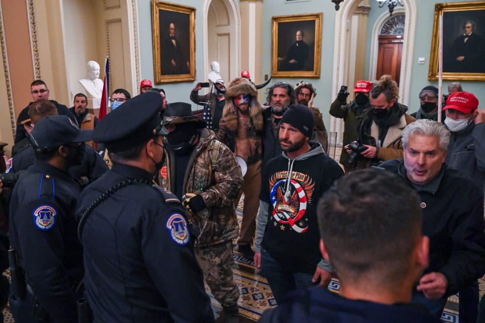 After breaking into the U.S. Capitol, protesters and Capitol Police stand in the hallway outside of the Senate chamber on Wednesday. (Saul Loeb/AFP via Getty Images)