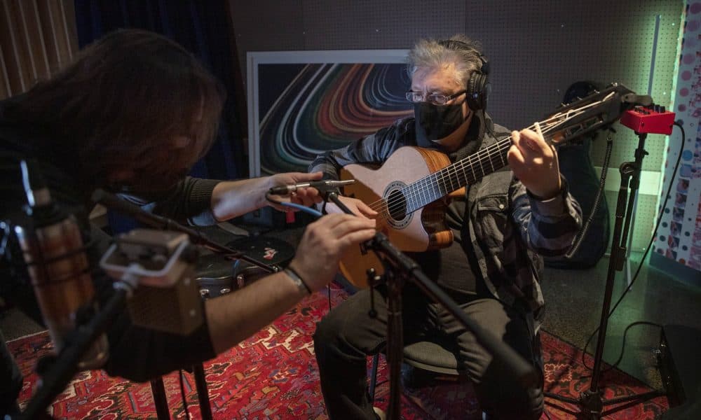 Music producer John Escobar sets up microphones in Studio B at The Record Co. for musician Claudio Ragazzi. (Robin Lubbock/WBUR)