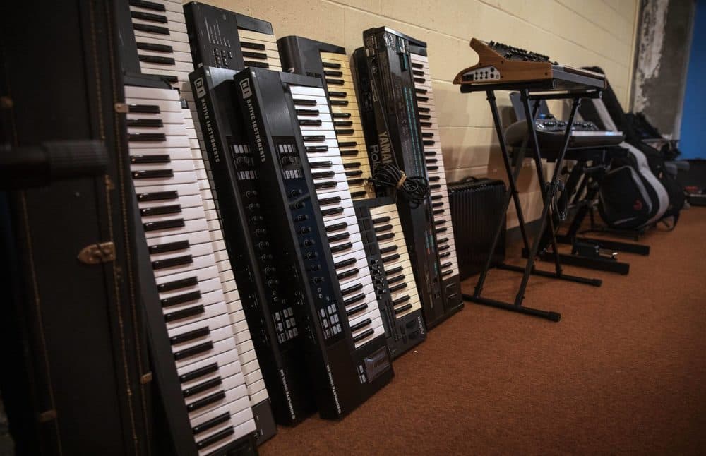Keyboards and guitars for use in the studios line a corridor wall at The Record Co. (Robin Lubbock/WBUR)