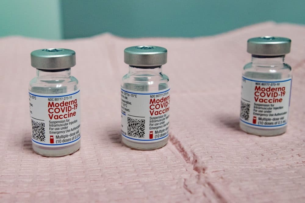 Three nearly empty bottles of the Moderna COVID-19 vaccine which can not be mixed to provide an addition dose for a vaccination shot. (Jesse Costa/WBUR)