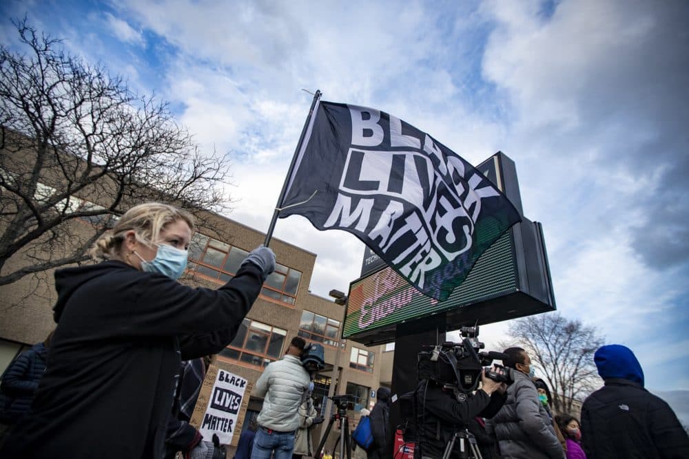 Laura Bilodeau holds a Black Lives Matter flag at the rally at Madison Park High School. (Jesse Costa/WBUR)