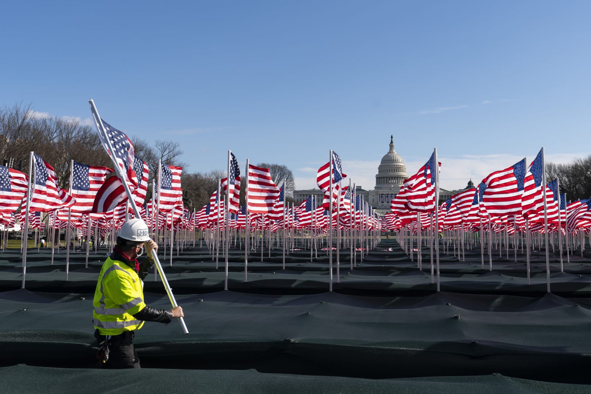 Workers place flags on the National Mall on Monday. (Alex Brandon/AP)