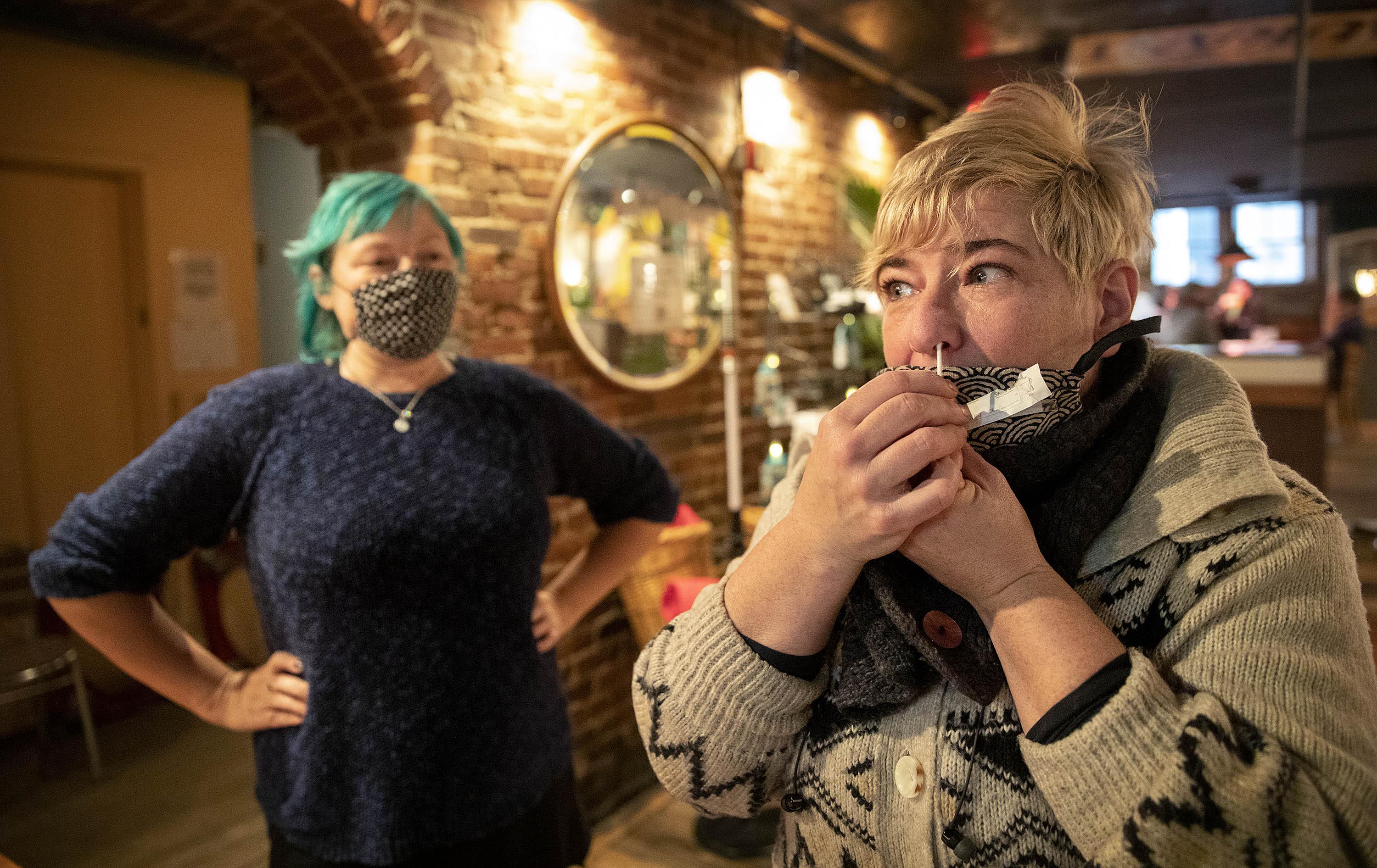 Grendel's owner Kari Kuelzer swabs her nose for a pooled coronavirus test for the restaurant's staff. (Robin Lubbock/WBUR)
